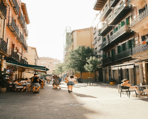 Person enjoying a gentle morning walk in a sunny Spanish city street